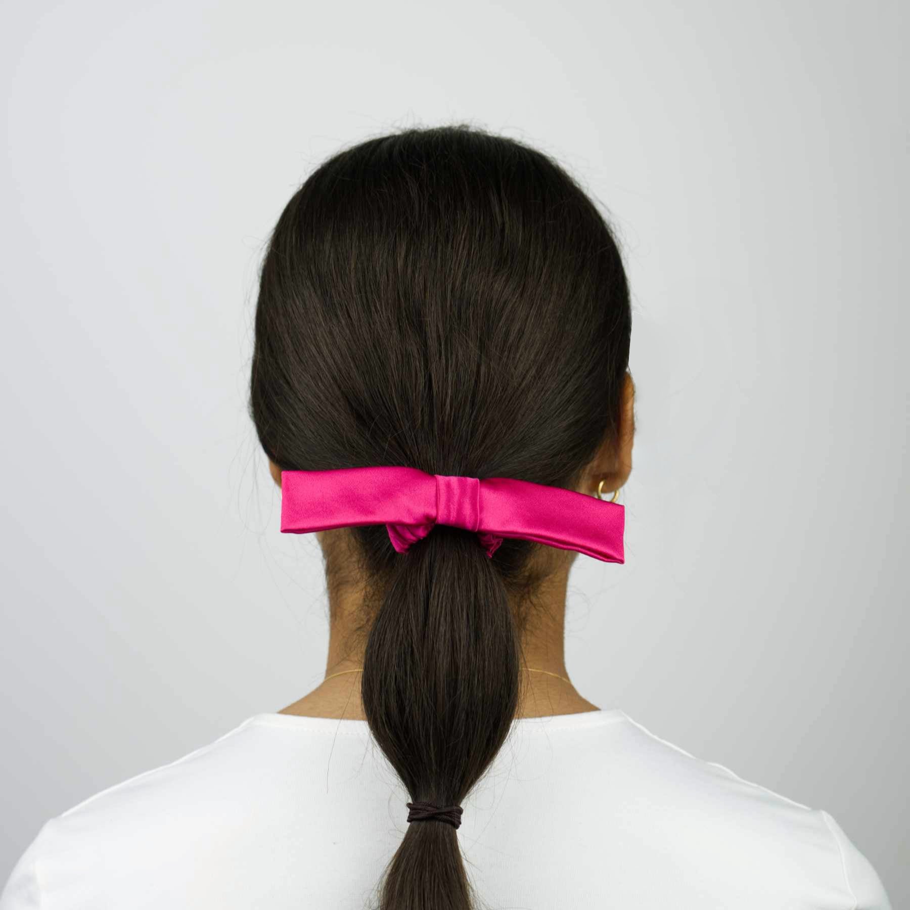 Le chouchou à nœud en soie rose fuchsia sublime vos cheveux. Fait main en France à partir de tissus de maisons du groupe LVMH. Édition limitée.