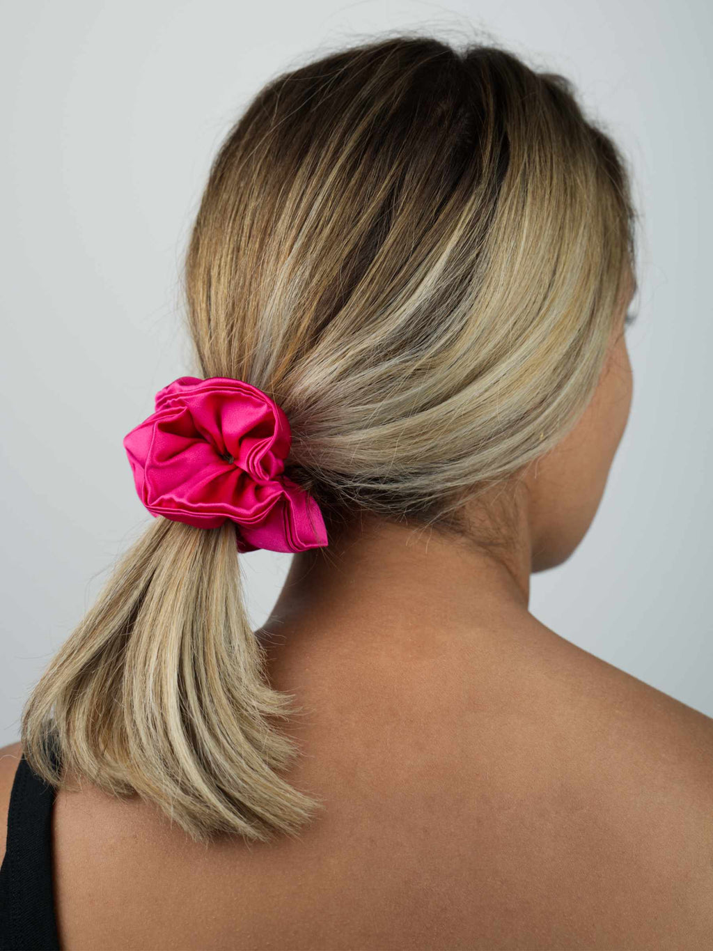 Ajoutez une note de couleur et de raffinement à vos coiffures grâce à ce chouchou en soie rose fuchsia en édition limitée